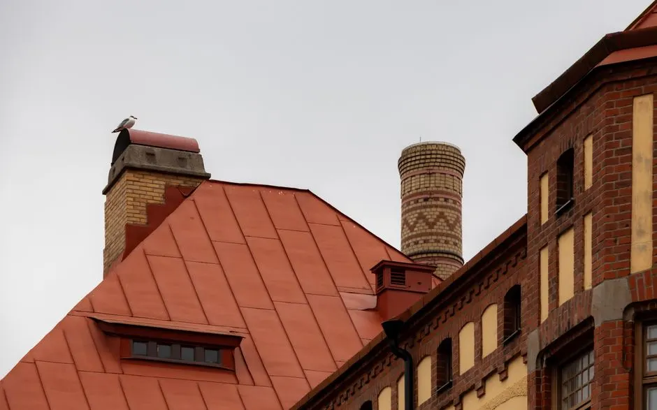 A seagull perched on a chimney of a red brick building in Göteborg, Sweden.